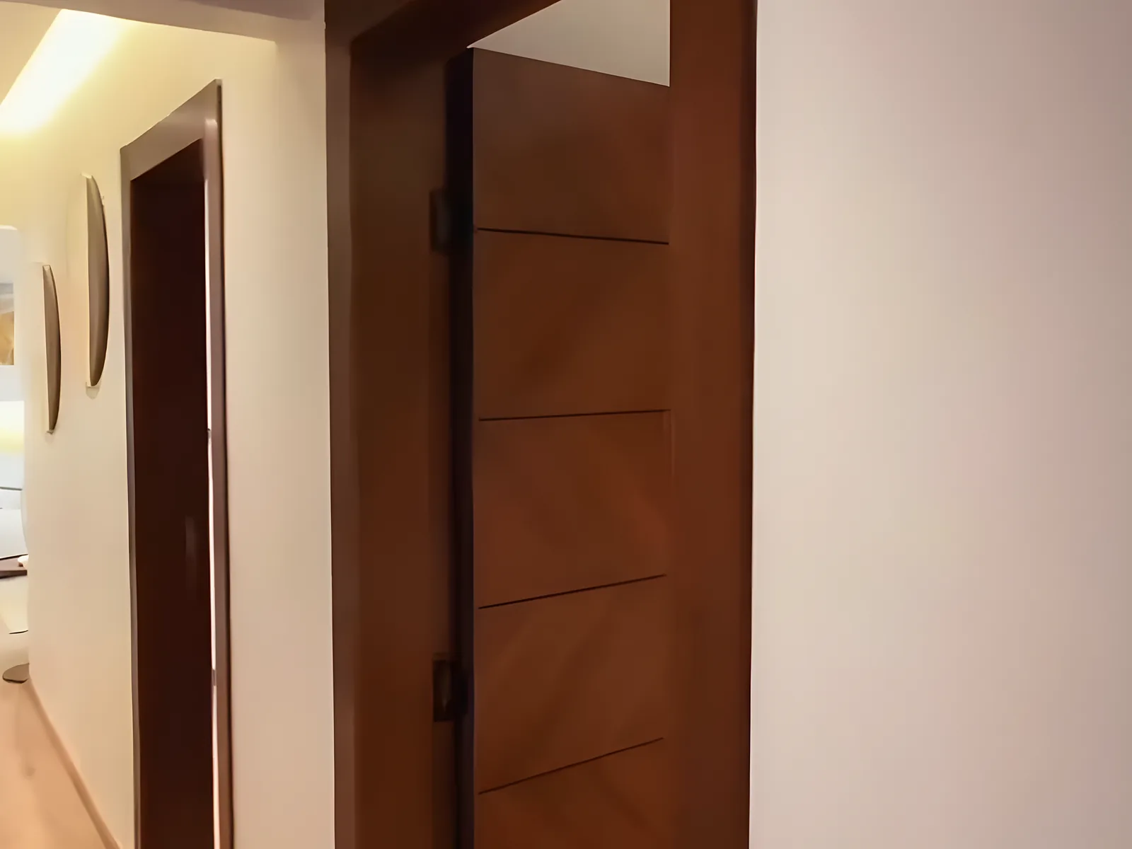 ممر بأبواب خشبية ومرايا جدارية دائرية